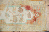 Distressed vintage Oushak rug mat featuring faded brick red cartouche and abrashed beige field.
