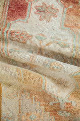 Distressed texture of vintage Oushak rug, with worn pile in brick red, beige, and mint.