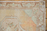 Oushak rug corner, distressed pile showing knot heads and faint foundation.