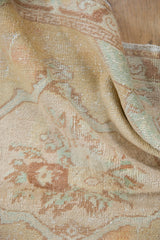 Hand-knotted Oushak rug pile showing distressed beige, apricot, copper, and seafoam tones.