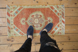 Distressed vintage Oushak rug showing even wear and a brick red abrashed field.