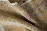 Distressed Oushak rug texture, showing even wear to knot heads, beige, violet, and turquoise tones.