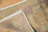 Distressed pile texture and visible foundation of the hand-knotted Oushak vintage rug.