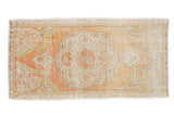 Decorative distressed Oushak rug mat, pale orange quatrefoil medallion on an ivory abrashed field.