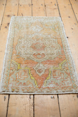 Distressed vintage Oushak rug showcasing its worn pile, pale tangerine, and ivory floral design.