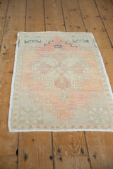 Distressed vintage Oushak rug, showing soft apricot, beige tones, and secured side selvage.
