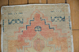 Distressed vintage Oushak rug detail: worn pile, apricot stepped pattern, and intact selvage.