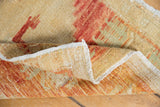 Distressed vintage Oushak rug corner displaying worn pile, visible hand-knotted foundation, and fringe.