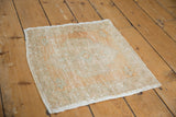 Distressed Oushak rug corner with textured pile, ivory and beige tones, and intact side selvage.