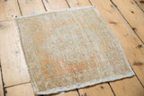 Distressed Oushak rug's side edge, showing mostly even worn pile and intact cord selvage.