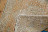Vintage Oushak rug corner showing distressed pile, intact selvage, and hand-knotted foundation.