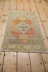 Turkish Oushak rug showing distressed texture, featuring an abrashed field and cochineal red geometric medallion.