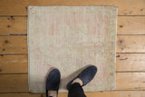 Distressed vintage Oushak square mat with pale pink, ivory, and seafoam tones, showing even wear.