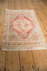 Distressed vintage Oushak rug corner with short, light fringe and wear.