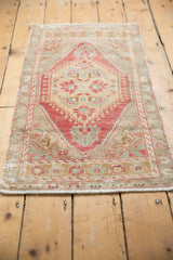 Distressed vintage Oushak rug runner with muted red medallion and soft beige pile.