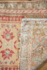Distressed Oushak rug: worn cherry red, beige pile, hand-knotted foundation, and fringe.
