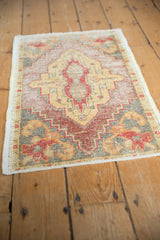 Distressed Oushak rug texture showing intricate grape motif, worn pile, burgundy, saffron, and oxidized silver.