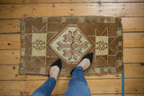 Distressed vintage Oushak rug mat with coffee brown field and muted starburst motifs.