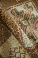 Distressed Oushak rug pile with even wear, showing coffee brown and pink hues.