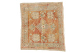 Distressed Oushak square rug with quatrefoil medallion and faded red-beige florals.