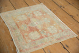 Distressed vintage Oushak rug mat with intact side selvage and low pile.