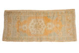 Vintage distressed Oushak runner with gold starburst medallion and muted green geometric florals.