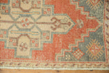 Stepped design detail in burnt orange, slate blue, and beige, showing mostly even pile wear.