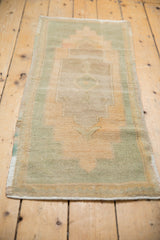 Distressed Oushak rug runner, featuring its stepped contour medallion in pale apricot and seafoam.