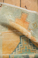 Distressed Oushak rug texture with stepped hook and latch pattern in pale teal, beige.