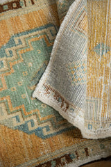 Distressed Oushak rug detail: teal, beige, brown geometric pattern and woven back.