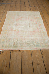 Distressed vintage Oushak rug with even pile wear showing subtle blush, ivory, and seafoam green.