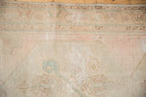 Distressed Oushak runner pile texture with even wear and faded blush, blue motifs.