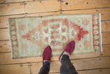 Vintage Distressed Oushak runner featuring faded wine red, seafoam green, ivory floral medallion, 1'7