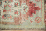 Vintage distressed Oushak rug border detail, faded wine red, seafoam green, ivory, with even wear.