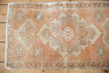 Distressed Oushak rug's geometric floral border in apricot and coffee brown tones.