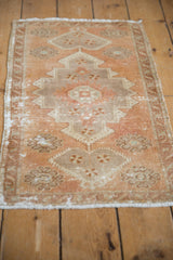 Left side of distressed vintage Oushak rug, showing serrated apricot and beige pattern.