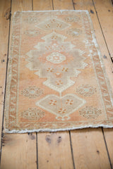 Distressed hand-knotted Turkish Oushak rug featuring serrated medallion, pinwheel motifs, and muted apricot, beige tones.