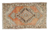 Distressed Oushak rug mat with diamond medallion, floral finials in pale rust, slate, seafoam green.