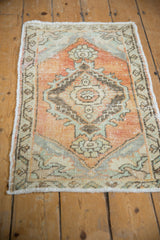 Distressed vintage Oushak rug displaying worn pile, diamond medallion, soft apricot, and seafoam green hues.