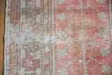 Vintage distressed Oushak rug close-up, highlighting worn pile texture, blush, and seafoam tones.