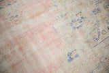 Distressed Oushak rug detail: dusty rose pile worn to foundation, with cobalt blue motifs.