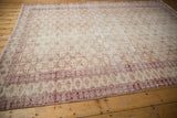 Distressed vintage Oushak rug border in black cherry red with starburst motifs and ivory tones.