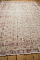 Distressed Oushak rug, close-up of worn pile, faded red trellis patterns, foundation showing.