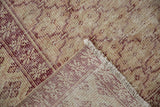Distressed Oushak carpet corner, black cherry red, ivory pile, foundation showing, fringe.