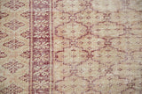 Distressed Oushak carpet detail: black cherry red motif, ivory field, wear to foundation.