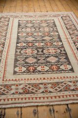 Decorative distressed Oushak carpet with geometric guls, pawn border in charcoal, cherry red, and ivory.