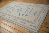 Textured distressed vintage Oushak rug with pale sky blue motifs and chocolate brown banded borders.