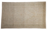 Distressed vintage Oushak rug with subtle medallion and stepped spandrels in muted ivory and beige.