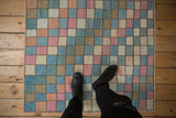 Distressed vintage Oushak rug featuring a happy checkered pattern in blue, pink, and beige.