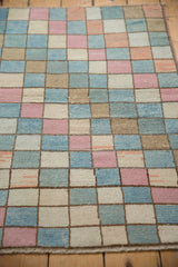 Varied texture and pastel blocks of a distressed Oushak checkered rug.